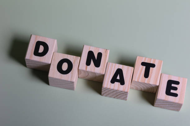 istock Donate word on wooden block  on green background 1420919024