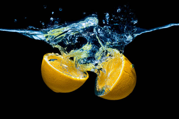 istock Halved lemon with water splashes on black 1420920704