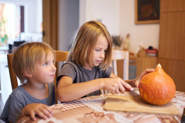 istock Young kids carving Halloween pumpkin 1420920719