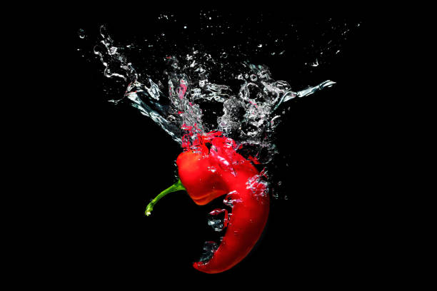 istock Curly chile pepper splashing in water on black 1420920811