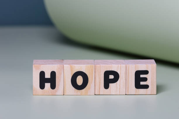 istock HOPE word on wooden block  on green background 1420920986