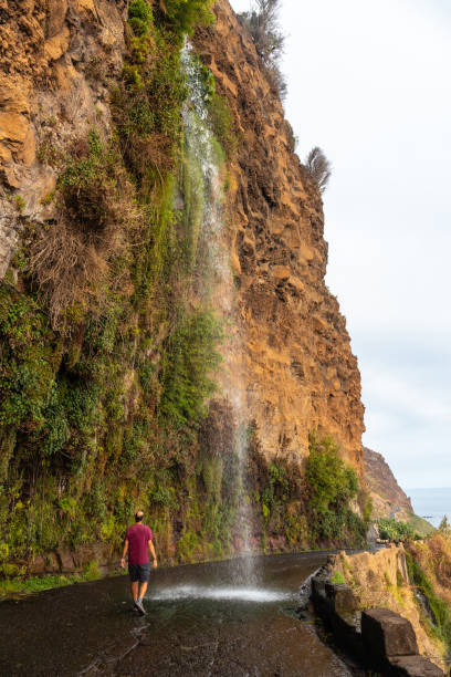 istock A young man looking at the waterfall that falls on the road called Anjos Waterfall, Madeira 1420921220