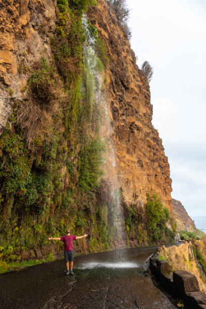 istock A young man looking at the waterfall that falls on the road called Anjos Waterfall, Madeira 1420921249