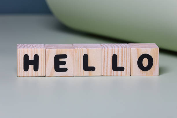 istock HELLO word on wooden block  on green background 1420922212