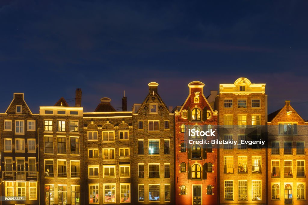Damrak, Amsterdam, Netherlands. View of houses during sunset. The famous Dutch canals. A cityscape in the evening. Travel photography. Amsterdam Stock Photo