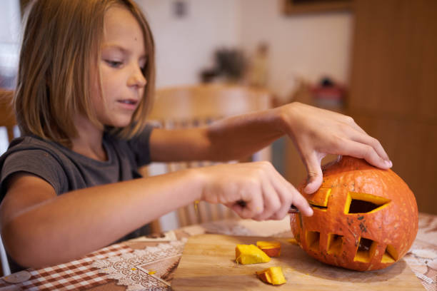 istock 8 year old boy carving Halloween pumpkin 1420924384