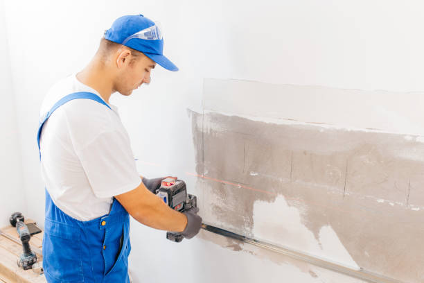 istock Worker in grey protective gloves installation building laser level with red beams on rail at wall 1420928509