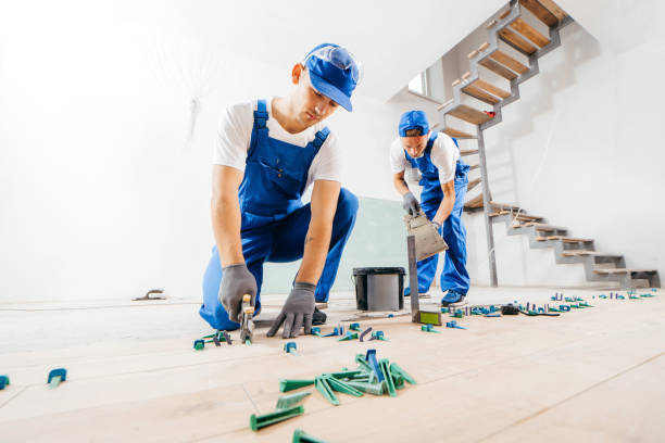 istock Two workers in a special uniform laying tiles with tile leveling system and laser level on the floor in a new house 1420928922