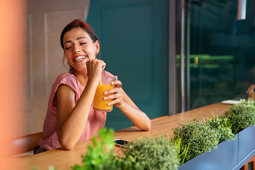 Young girl having a good morning healthy smoothie drink made of super foods. People health concept