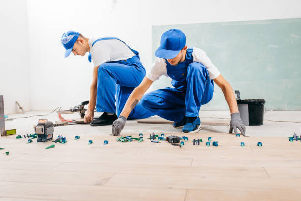 istock Two workers in a special uniform laying tiles with tile leveling system and laser level on the floor in a new house 1420929026