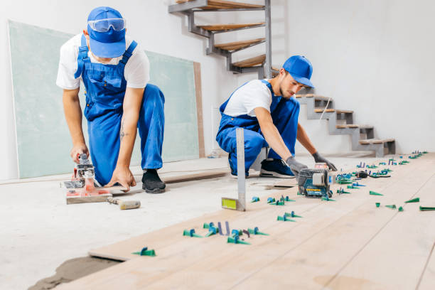 istock Two workers in a special uniform laying tiles with tile leveling system and laser level on the floor in a new house 1420929030