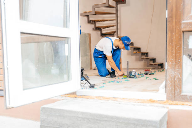 istock Two workers in a special uniform laying tiles with tile leveling system and laser level on the floor in a new house 1420929042
