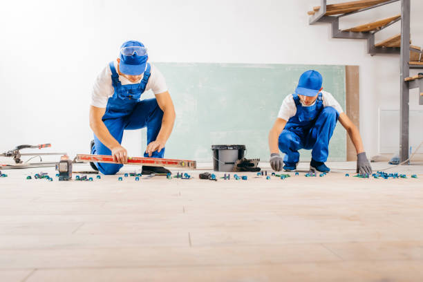 istock Two workers in a special uniform laying tiles with tile leveling system and laser level on the floor in a new house 1420929057