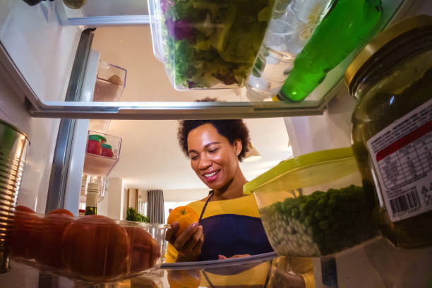 Woman looking at food in refrigerator stock photo