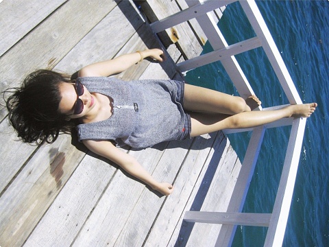 a beautiful woman lying on wooden bridge in the island