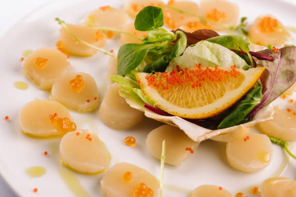 fresh scallops with red caviar on plate