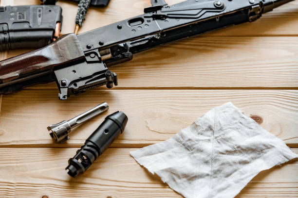 istock Black disassembled shotgun and cleaning tools on wooden table . 1420932693