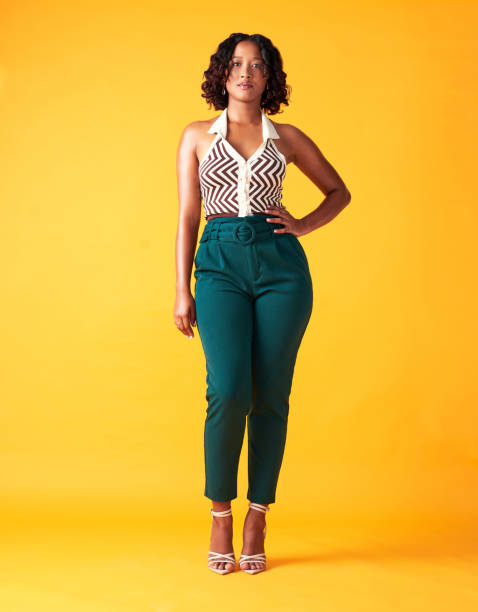 Luxury, fashion designer or student standing with empowerment, serious and commanding respect portrait. Creative, beauty and style trend setter with a retro and vintage aesthetic yellow background