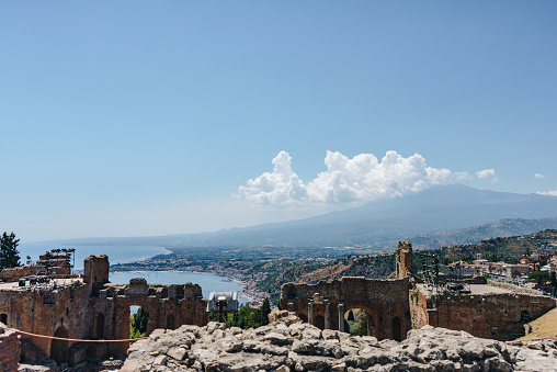 Taormina view from antico Greco stock photo\nThe Greek theater and Mount Etna volcano, Taormina, Sicily, Italy