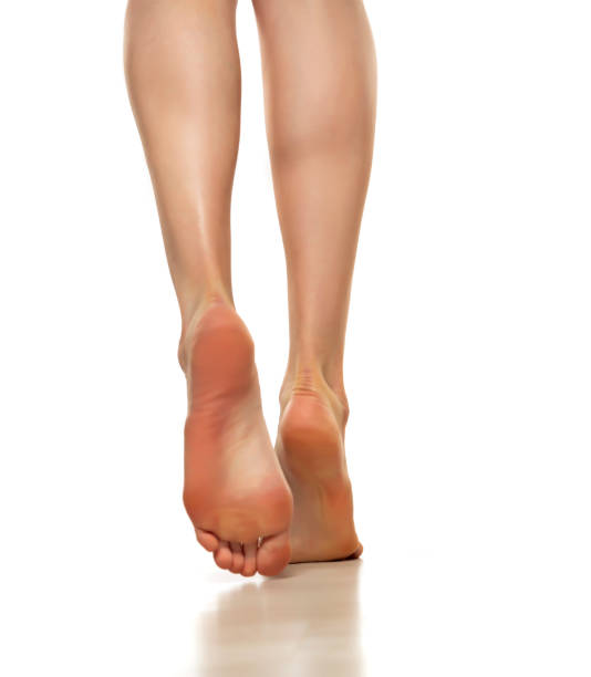 istock Slender beautiful female bare feet rear view on a white background 1420935786