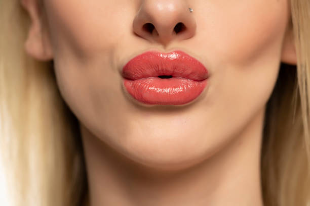 macro close-up de lábios inchados após injeções de higaluron, aumento dos lábios em um fundo branco - big lips - fotografias e filmes do acervo