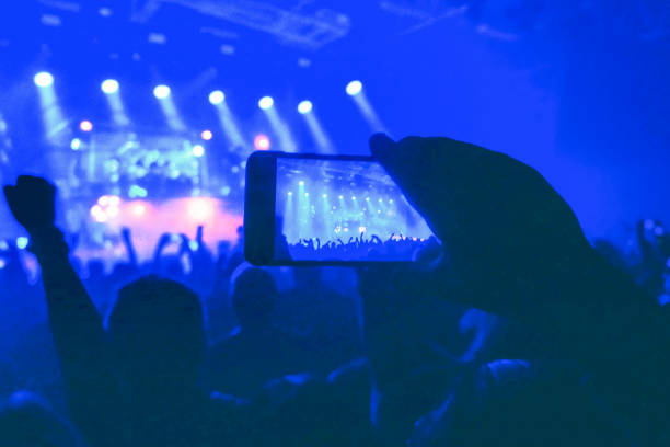 istock Cropped hand take photo with mobile phone during concert 1420936531