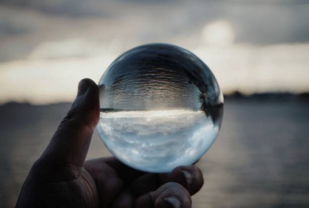 istock Cropped hand holding crystal ball against sea 1420937196