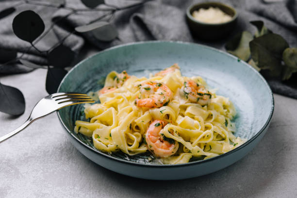 Italian pasta fettuccine or tagliatelle with shrimps stock photo