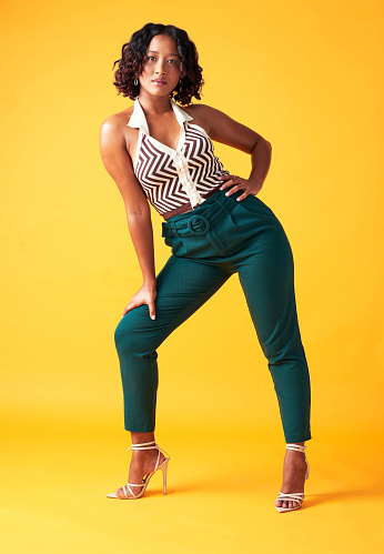 Stylish, fashion and trendy woman model in modern outfit against mockup studio background. Portrait of an aesthetic African American young model relaxing with a style or edgy outfit or clothing