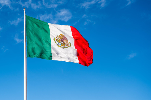 Mexican flag waving with blue sky and clouds in Mexico City - Flag Waving - Mexico Flag