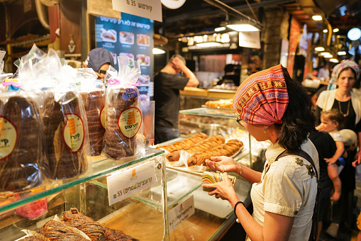 Jerusalem, Israel, 8 august 2022: A tourist shopping for sweet food in Mahane Yehuda market in Jerusalem.