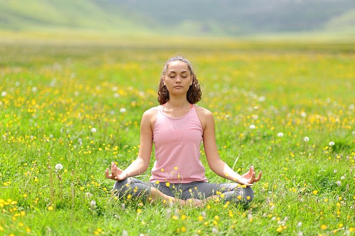 Yogi doing yoga on the grass in the mountain