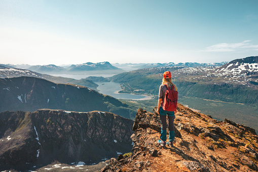 Woman hiking in Norway enjoying aerial view on cliff outdoor Travel adventure tour active vacations healthy lifestyle climbing to Hamperokken mountain sustainable tourism