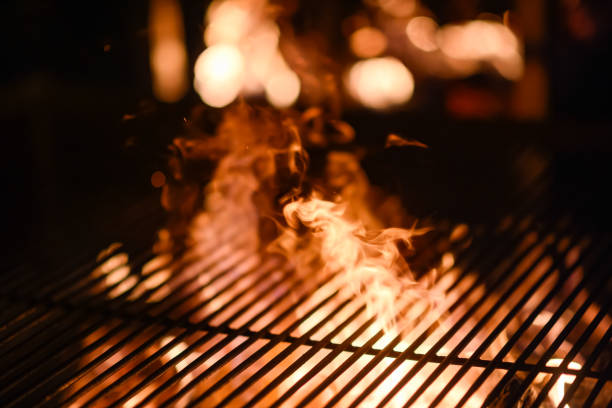 Flame through Barbecue Braai Grid at Night stock photo