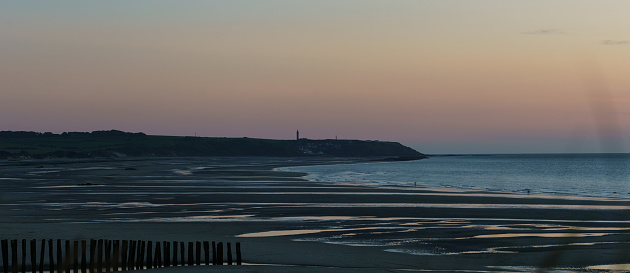 Panorama Cap Gris-Nez with lighthouse in beautiful twilight after sunset on opal coast at north sea with sandy beach in foreground, Wissant, France