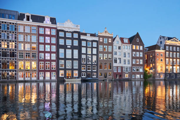 istock Amsterdam narrow waterfront canal houses at night 1420949214