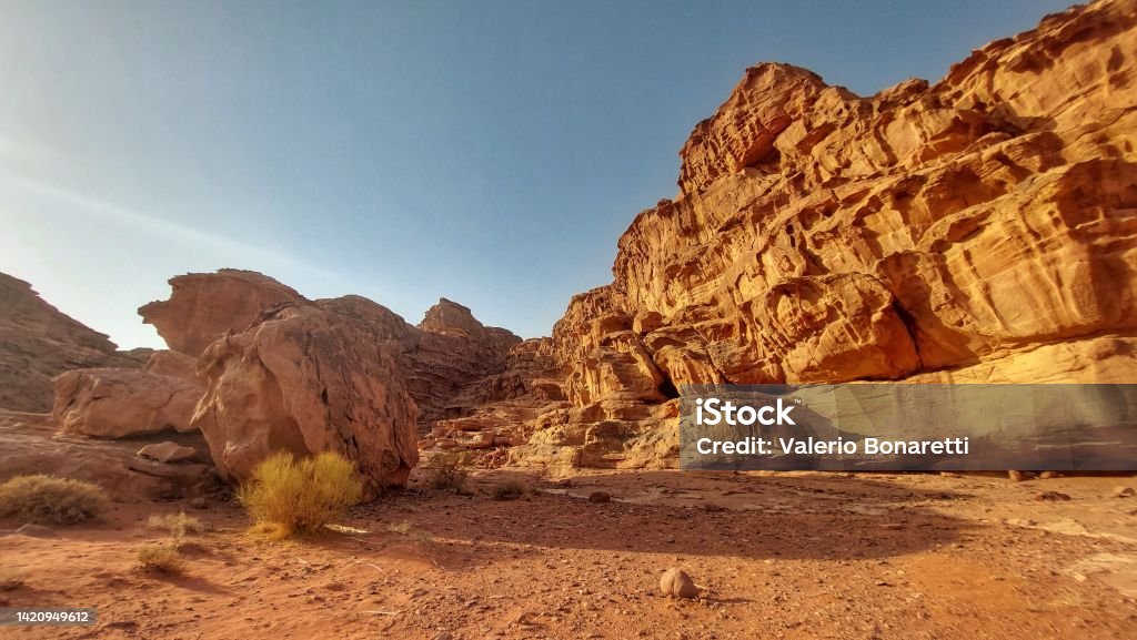 Glimpses of Wadi Rum: desert and red sand at sunset Wadi Rum, the valley carved over millennia by the flow of a river in the sandy soil and granite rock of southern Jordan Absence Stock Photo