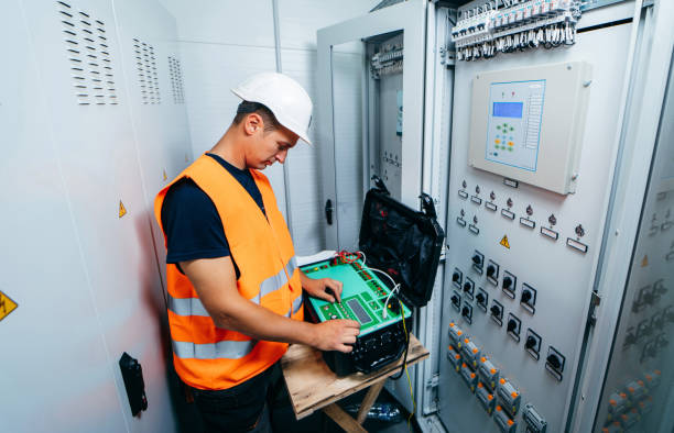 istock Adult electrician builder engineer testing and screwing equipment of device for secondary current and voltage testing of relay protection and automation devices of modern electricity power station. 1420952413