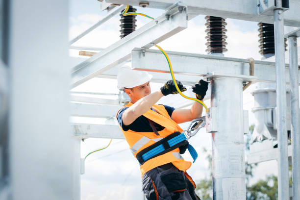 istock Electrician in protective helmet working on high voltage power lines. Highly skilled workmen servicing the electricity grid. Modern power station with power towers 1420952833