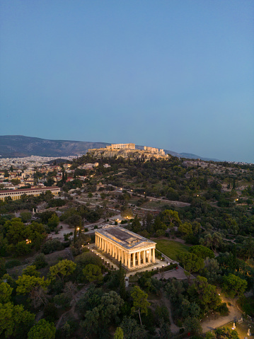 Aerial vertical photo of Athens Historical Center - Acropolis of Athens, Monastiraki, Thisio, Ancient Agora, pedestrian streets, parks, lycabetus hill and the hill of Filopappou - Greece, at dusk