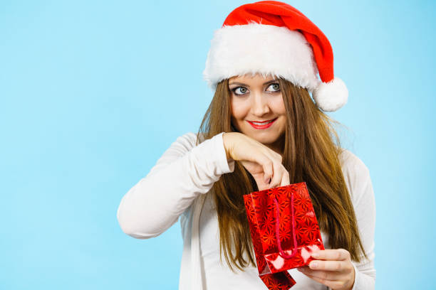 istock Christmas woman puts her hand into gift bag 1420955516