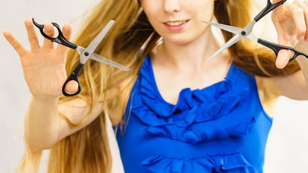 istock Young woman with scissors for haircutting 1420957681