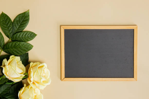 istock A black frame with roses and green leaves over the brown background. 1420957871