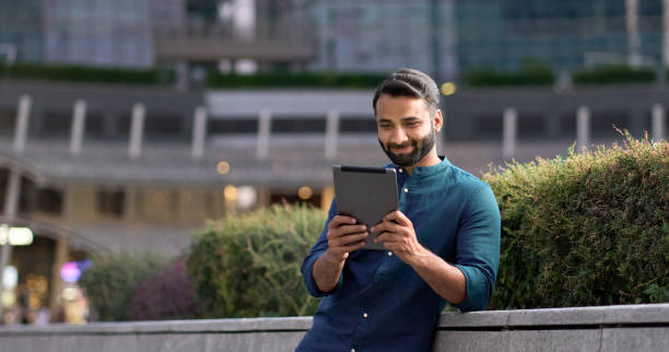 istock Professional indian business man using digital tablet in night city park. 1420959420
