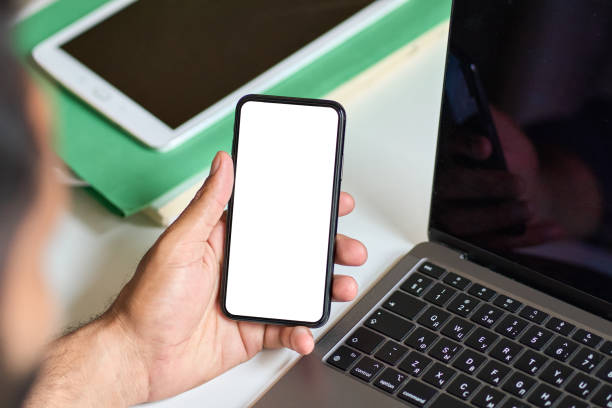 istock Business man holding mobile phone with mock up white screen at work. 1420975076