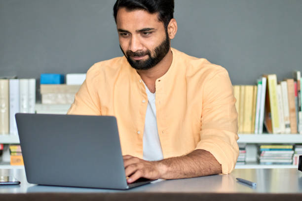istock Indian business man entrepreneur using laptop computer in office online working. 1420975092