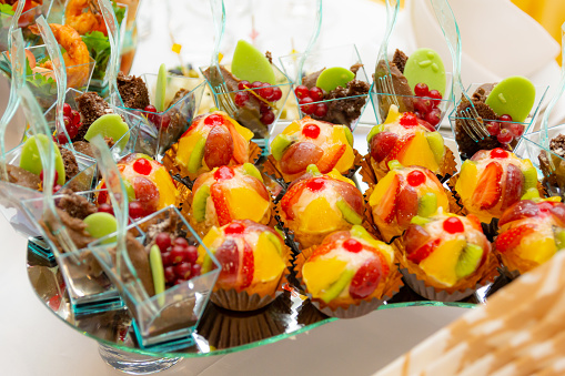 Cakes, fruits and desserts on the buffet. Luxurious table setting at the banquet. Restaurant service. Catering.