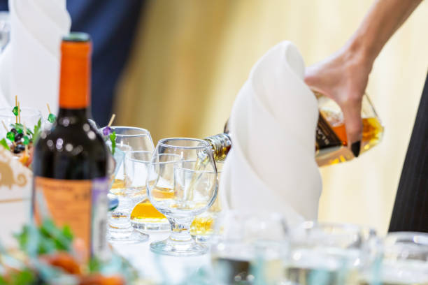 istock The waiter pours whiskey or cognac into a glass 1420975984