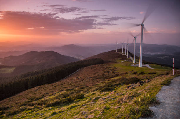 Photo of eolic generators spinning with the wind in the mountains at sunset