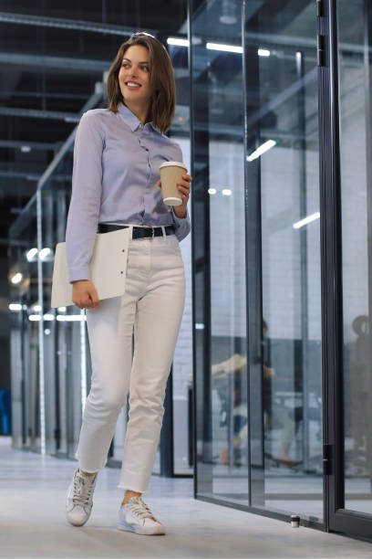 istock Businesswoman walking along the office corridor with documents. 1420980361